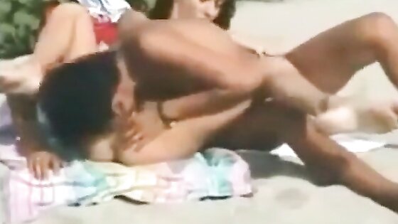 Two lesbians finger and lick each other on the beach