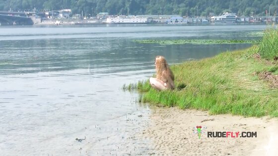 Playful blond nudist teen caught on camera naked at the beach