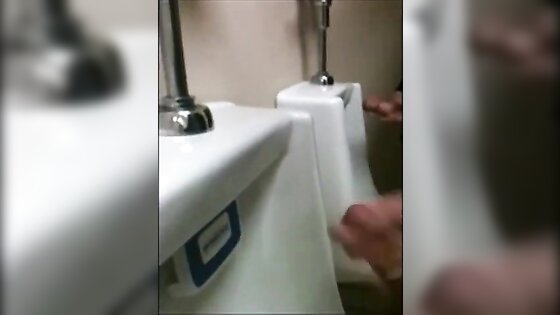 two slim dicks getting wanked at the urinals