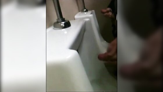 two slim dicks getting wanked at the urinals