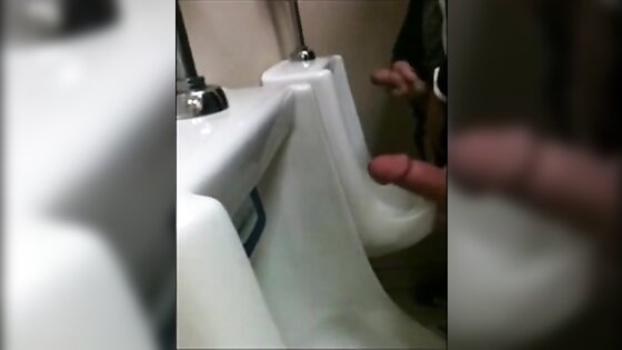 two slim dicks getting wanked at the urinals