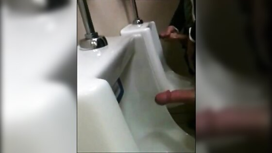 two slim dicks getting wanked at the urinals