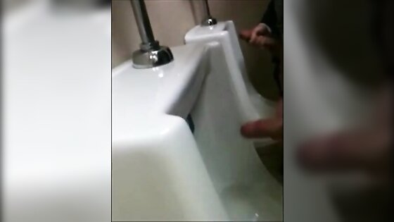 two slim dicks getting wanked at the urinals